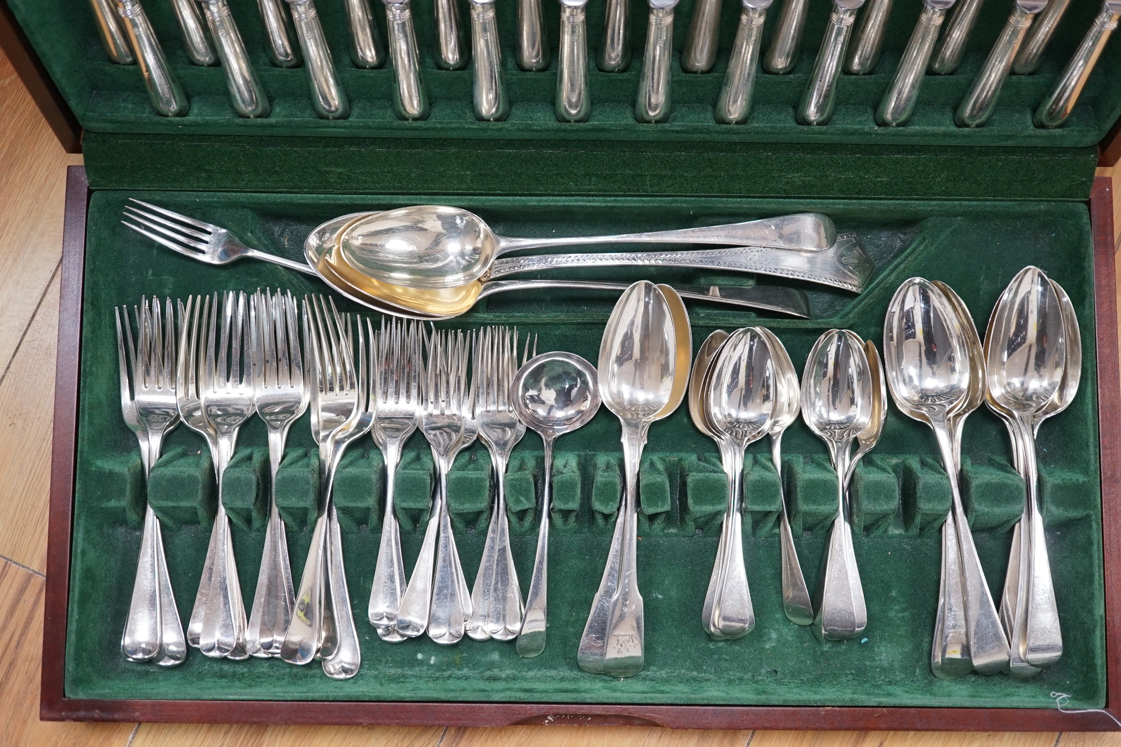 A part canteen of mainly 19th century and later silver cutlery, various patterns, dates and makers, comprising seventy eight items including modern table knives and one plated dessert fork, in a fitted wooden canteen